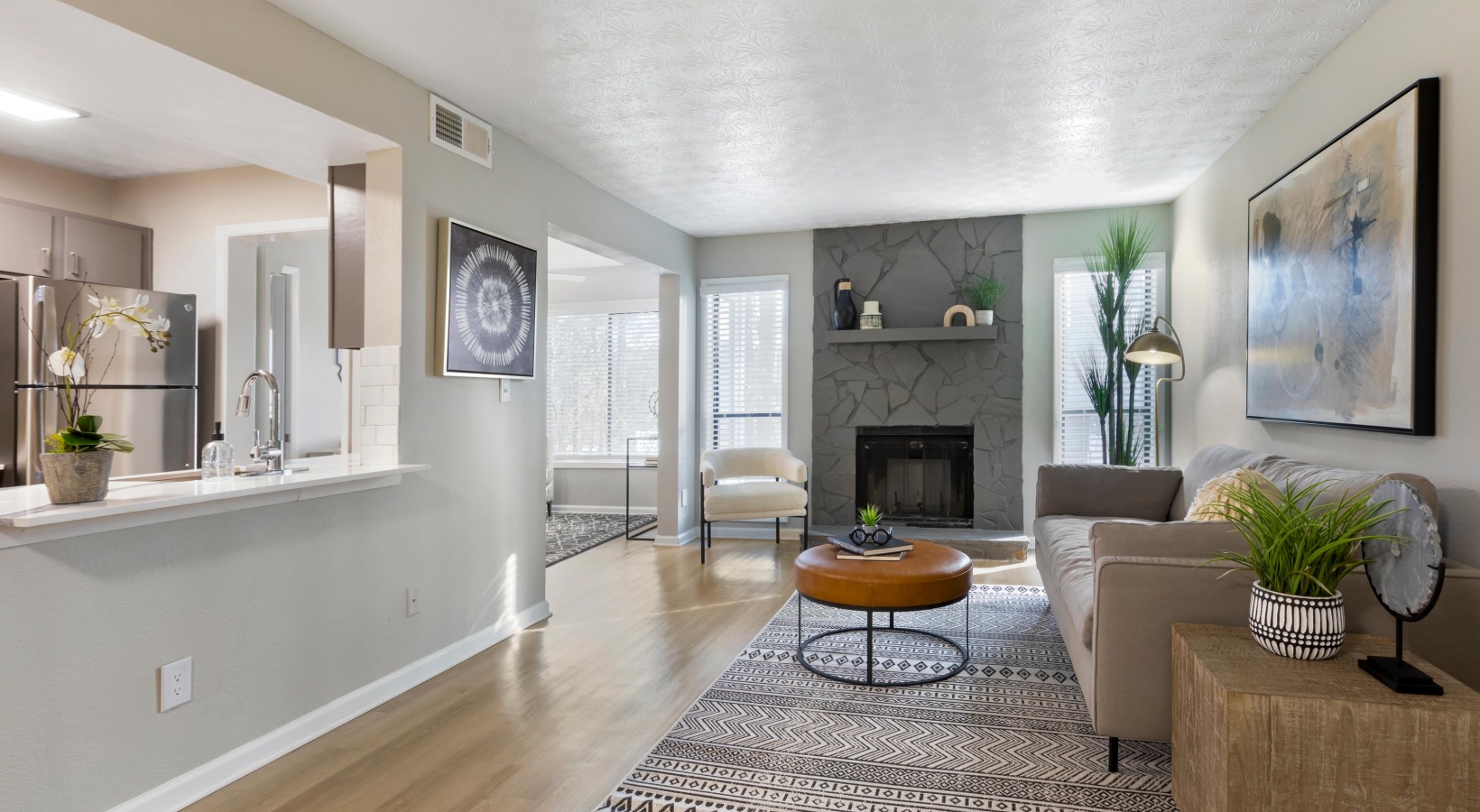 a living room with a fireplace and a kitchen at The The Breck