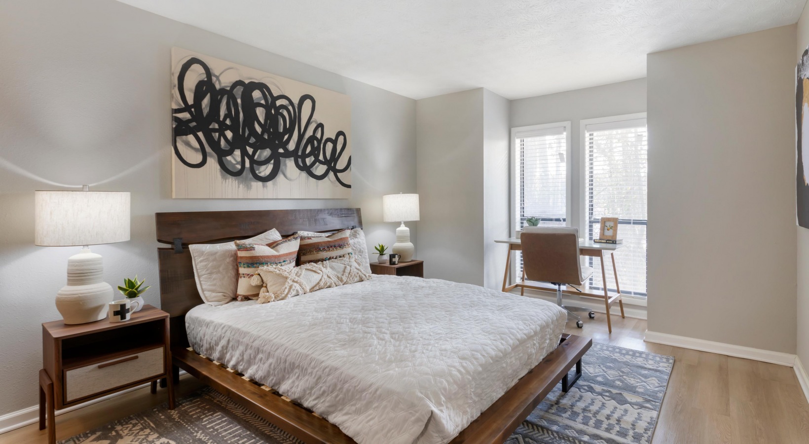 a bedroom with a bed, nightstands and a painting at The The Breck