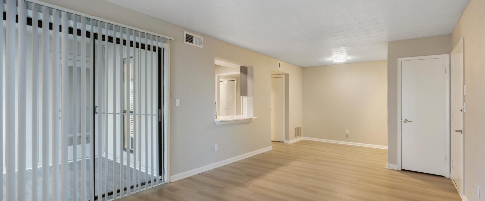 empty room with sliding glass doors and hardwood floors at The The Breck