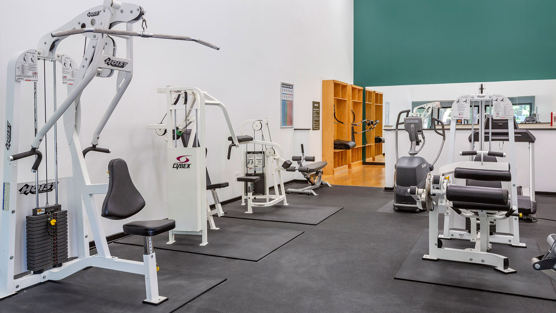 a gym room with equipment and a green wall at The  Breck