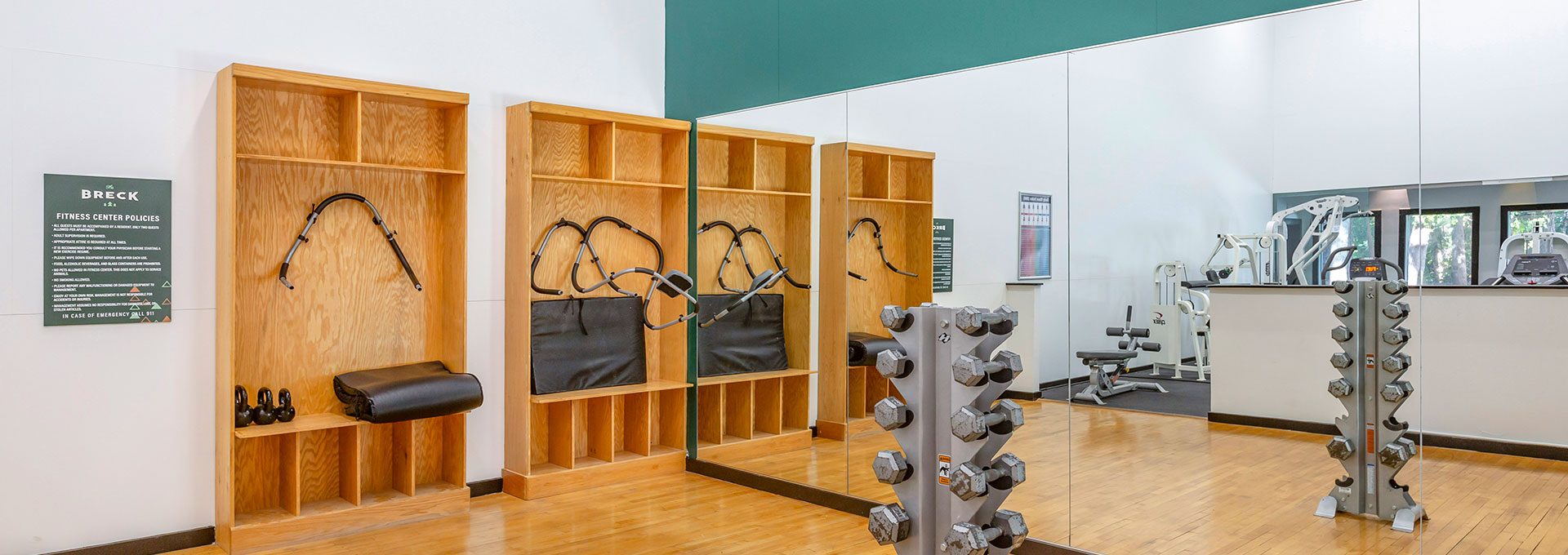 a gym room with mirrors and weights on the wall at The Breck