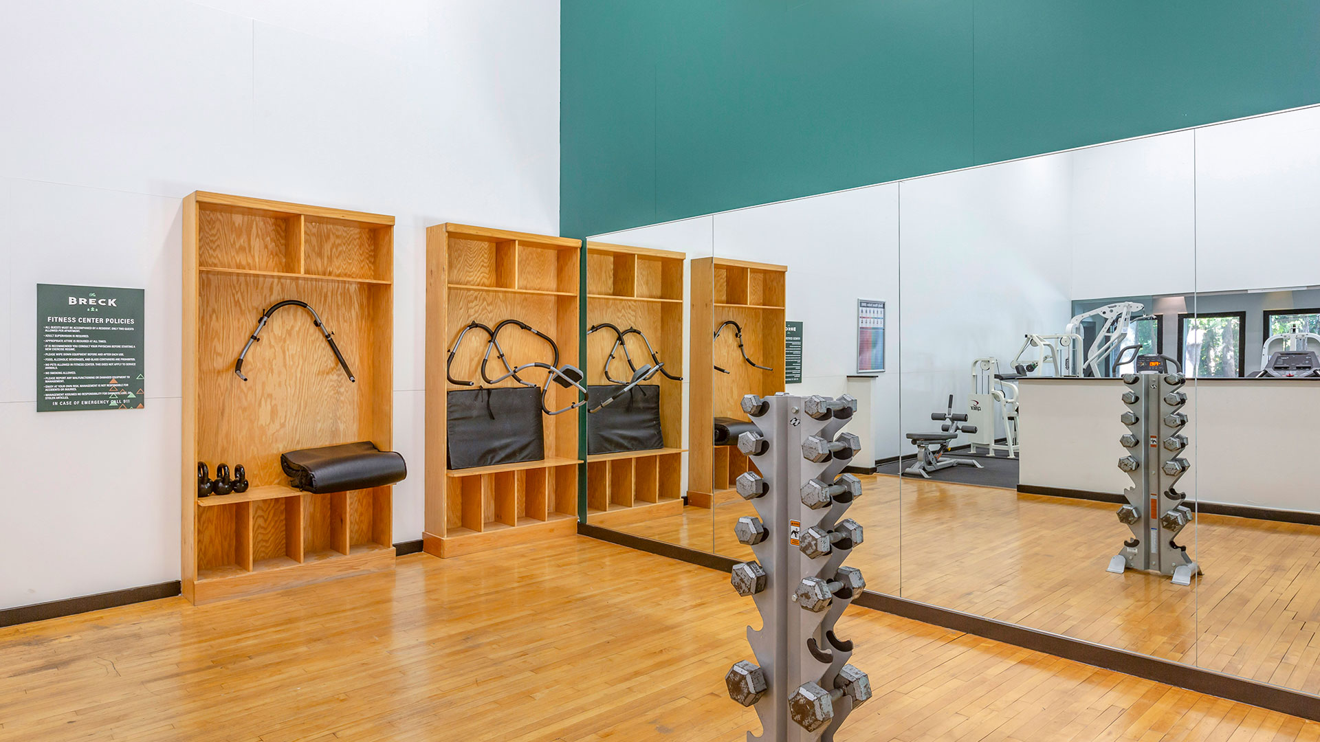 a gym room with mirrors and weights on the wall at The  Breck