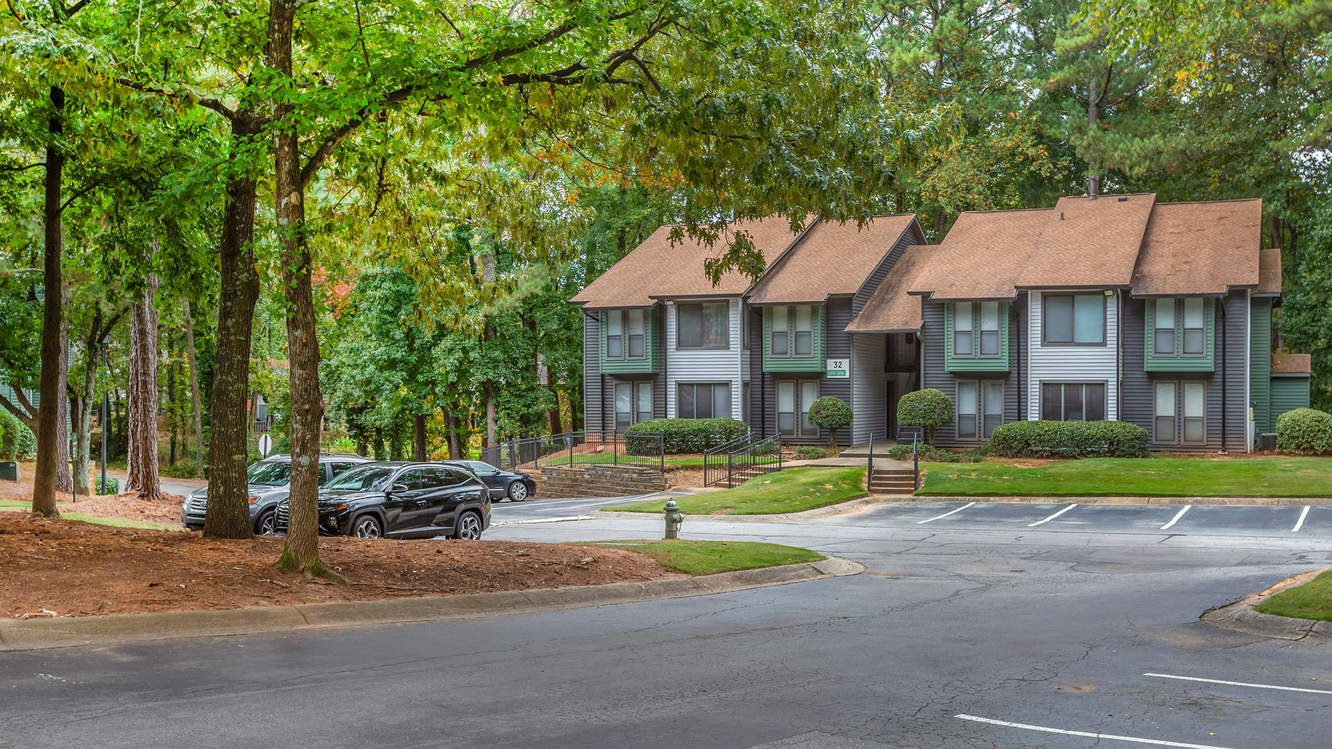 the apartment complex is surrounded by trees and parking lots at The  Breck
