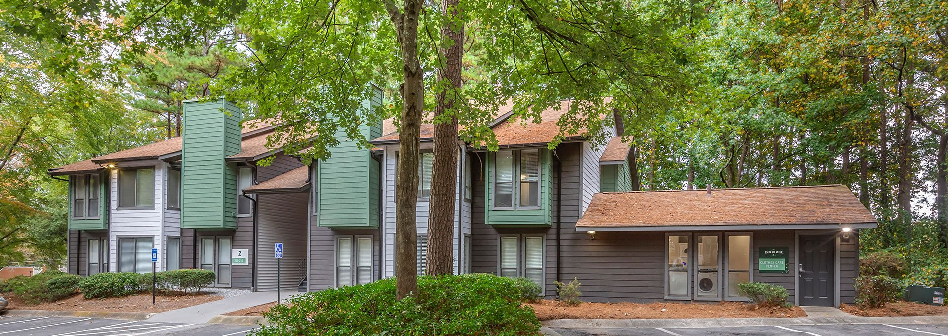 the exterior of an apartment complex with trees and bushes at The  Breck